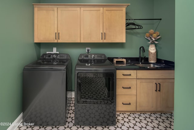 washroom with a sink, cabinet space, and washer and dryer