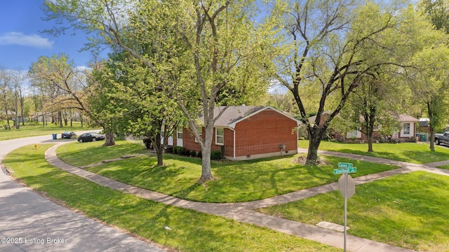 view of home's exterior featuring a lawn and brick siding