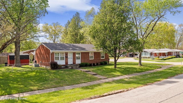 view of front of property with fence, brick siding, a front yard, central AC unit, and concrete driveway