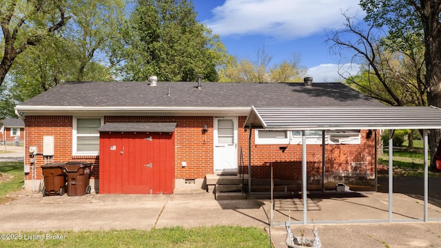 back of house featuring entry steps, a shingled roof, crawl space, and brick siding