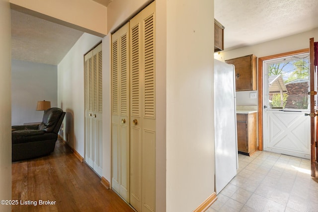 hallway with baseboards and a textured ceiling