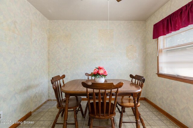 dining space featuring wallpapered walls, ceiling fan, baseboards, and light floors
