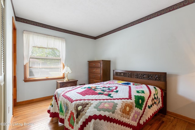 bedroom featuring baseboards and wood finished floors