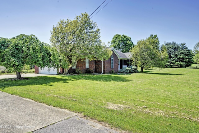 view of front of house featuring brick siding, a garage, a front lawn, and concrete driveway