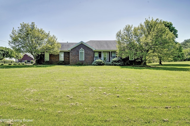 single story home featuring brick siding, a front yard, and roof with shingles