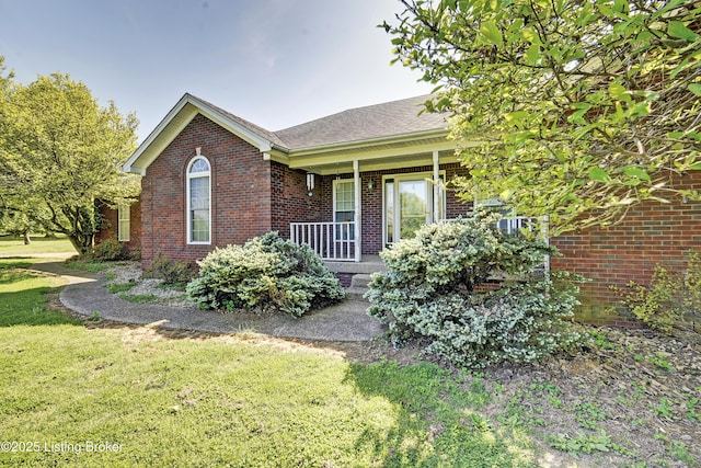 ranch-style house with brick siding, a front yard, and a porch