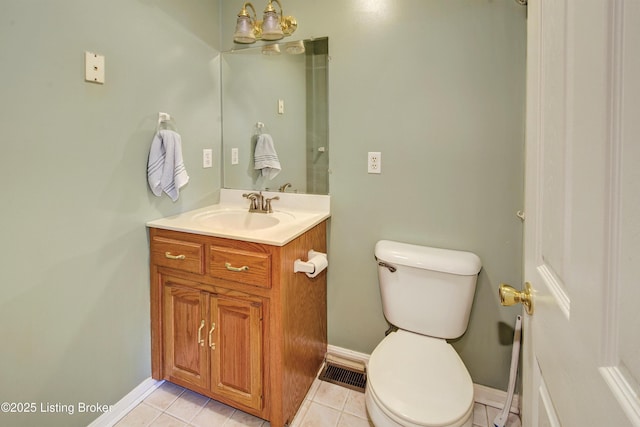 half bath featuring vanity, tile patterned floors, and toilet