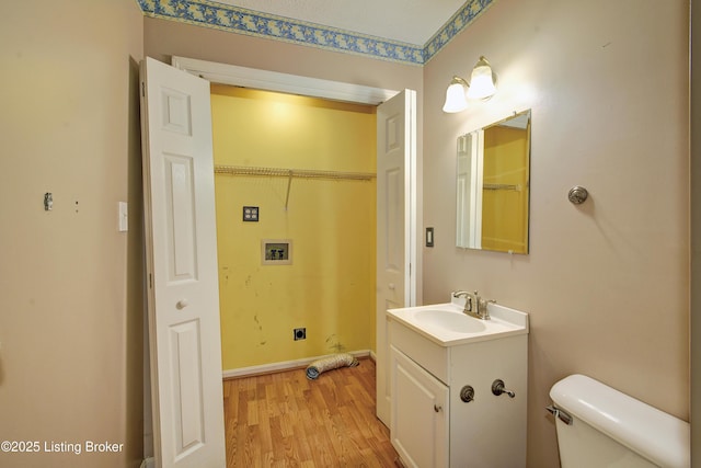 bathroom featuring toilet, wood finished floors, and vanity