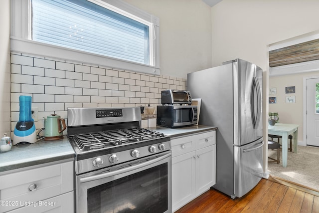 612 E Ormsby Ave, Louisville, KY 40203 - kitchen featuring stainless steel appliances, tasteful backsplash, light wood-type flooring, white cabinetry, and light countertops