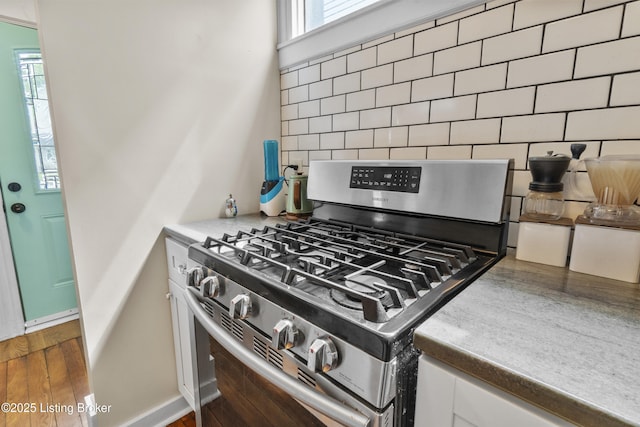 612 E Ormsby Ave, Louisville, KY 40203 - kitchen view of stainless steel gas stove, white cabinetry, and decorative backsplash