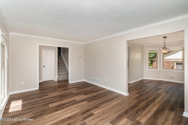 empty room featuring visible vents, a textured ceiling, stairs, and a chandelier