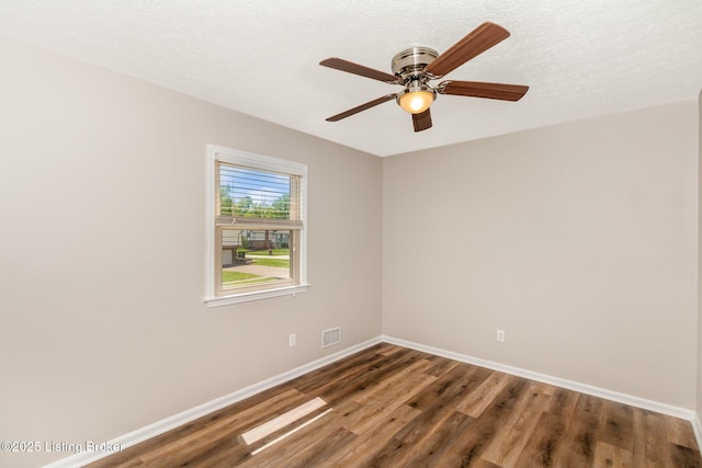 unfurnished room featuring ceiling fan, a textured ceiling, visible vents, wood finished floors, and baseboards