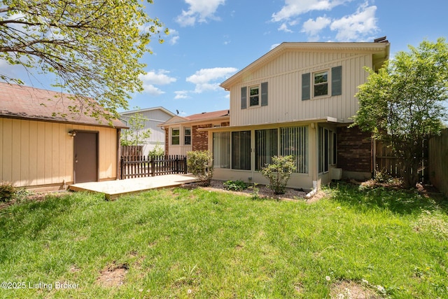 back of house with fence, a sunroom, a shed, a lawn, and an outdoor structure