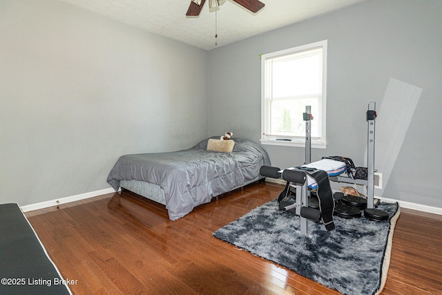 bedroom with a ceiling fan, baseboards, and wood finished floors