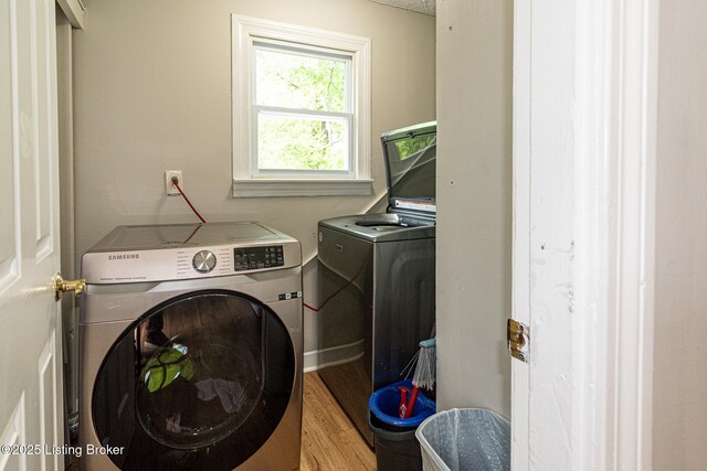 3962 Craig Ave, Louisville, KY 40215 - clothes washing area featuring washing machine and clothes dryer and light wood-style flooring
