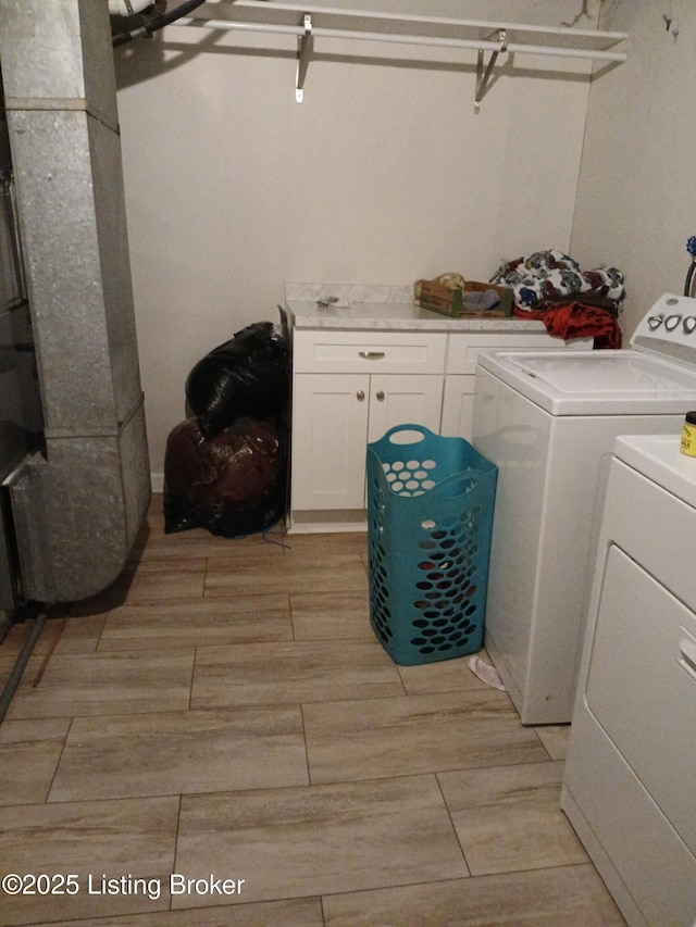 washroom featuring light wood finished floors, cabinet space, and independent washer and dryer