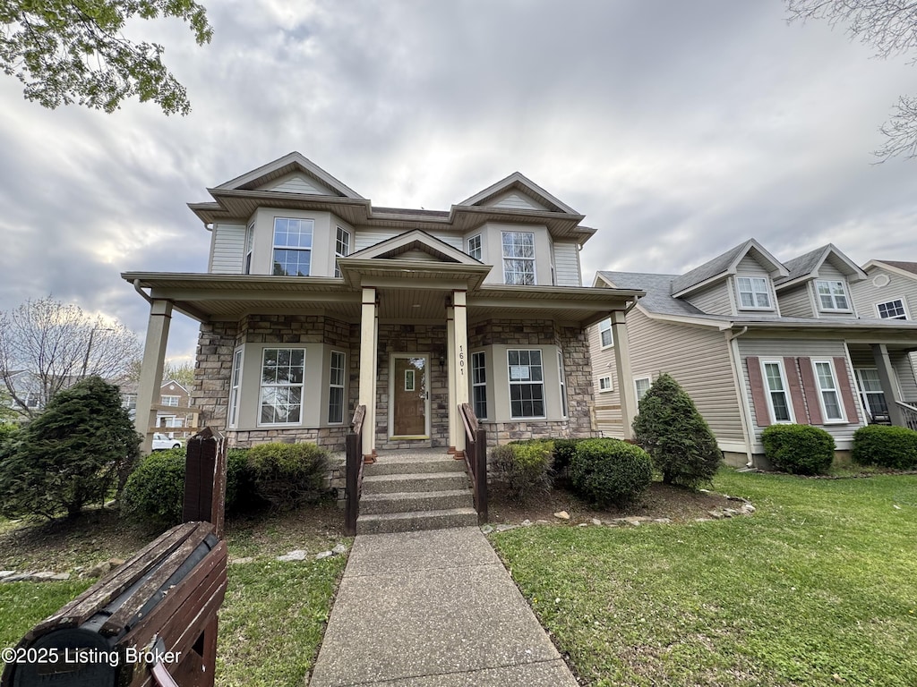 view of front of property featuring a porch, a front yard, and stone siding