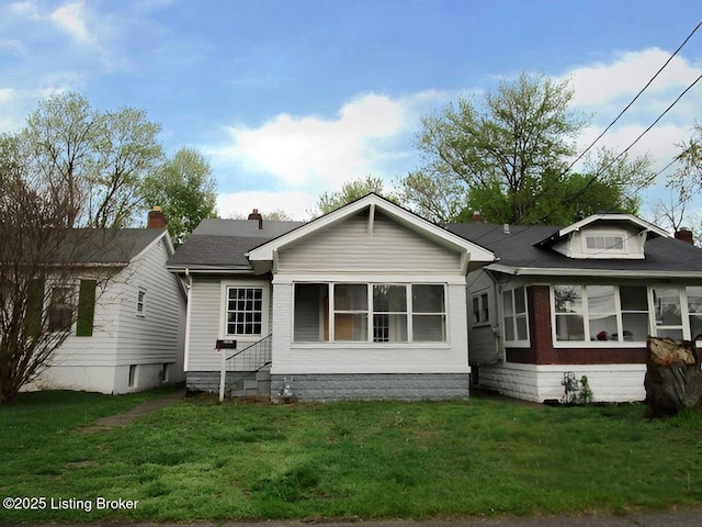 view of front facade featuring entry steps, a front lawn, and brick siding