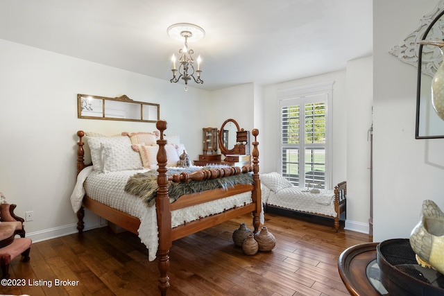 bedroom featuring wood-type flooring, baseboards, and a notable chandelier