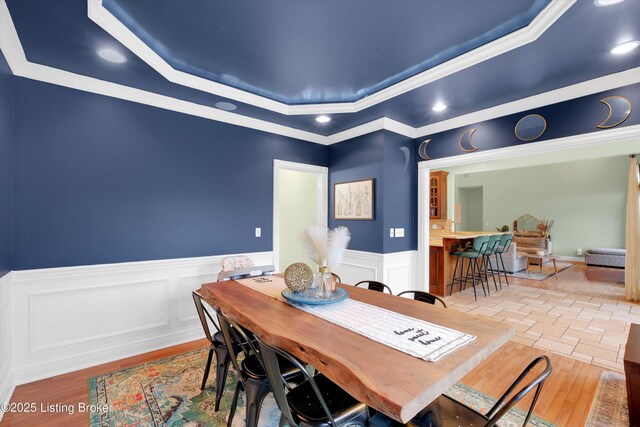 302 Hampton Rd, Brandenburg, KY 40108 - dining space with wainscoting, a raised ceiling, ornamental molding, recessed lighting, and light wood-style flooring