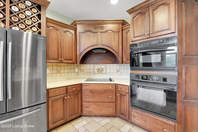 302 Hampton Rd, Brandenburg, KY 40108 - kitchen with decorative backsplash, brown cabinets, light countertops, freestanding refrigerator, and black electric stovetop