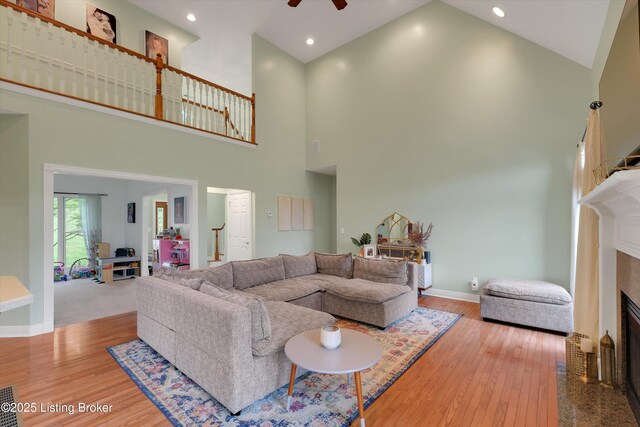 302 Hampton Rd, Brandenburg, KY 40108 - living room featuring wood finished floors, baseboards, ceiling fan, a high ceiling, and a fireplace with flush hearth