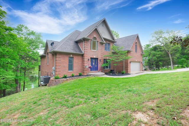 302 Hampton Rd, Brandenburg, KY 40108 - view of front facade featuring a front yard, brick siding, central AC, an attached garage, and a shingled roof