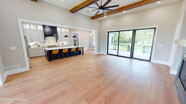 2045 W Rhudes Creek Rd, Elizabethtown, KY 42701 - living area featuring beam ceiling, a fireplace, a ceiling fan, light wood-type flooring, and visible vents
