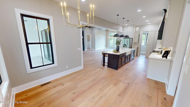 2045 W Rhudes Creek Rd, Elizabethtown, KY 42701 - kitchen featuring decorative light fixtures, visible vents, light countertops, stainless steel fridge, and an inviting chandelier