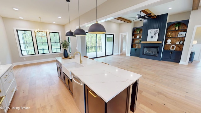 2045 W Rhudes Creek Rd, Elizabethtown, KY 42701 - kitchen with a large fireplace, dishwasher, a sink, open floor plan, and light wood-style flooring