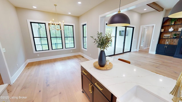 2045 W Rhudes Creek Rd, Elizabethtown, KY 42701 - kitchen featuring decorative light fixtures, light wood-type flooring, open floor plan, and a notable chandelier