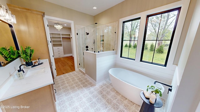 2045 W Rhudes Creek Rd, Elizabethtown, KY 42701 - full bath with double vanity, a walk in closet, a freestanding tub, a stall shower, and recessed lighting