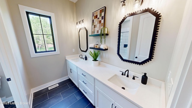 2045 W Rhudes Creek Rd, Elizabethtown, KY 42701 - bathroom with baseboards, double vanity, tile patterned floors, and a sink