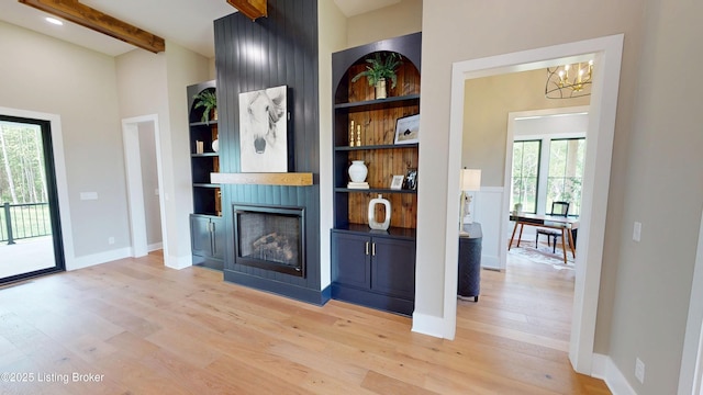 2045 W Rhudes Creek Rd, Elizabethtown, KY 42701 - living room featuring an inviting chandelier, built in features, a fireplace, beamed ceiling, and light wood-style floors