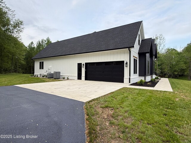 2045 W Rhudes Creek Rd, Elizabethtown, KY 42701 - view of home's exterior featuring roof with shingles, an attached garage, cooling unit, a yard, and driveway