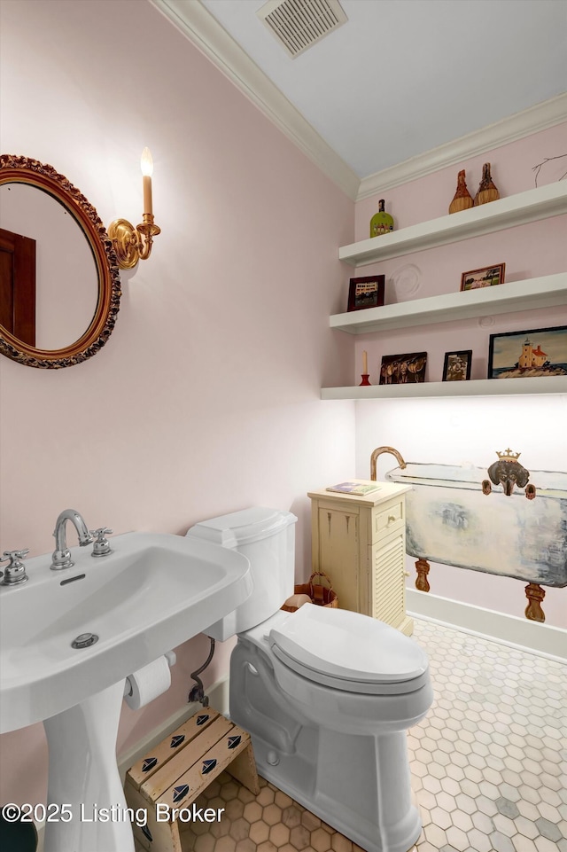 bathroom featuring ornamental molding, toilet, and visible vents