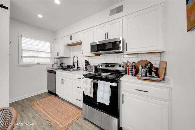 2100 Murray Ave, Louisville, KY 40205 - kitchen with appliances with stainless steel finishes, a sink, backsplash, white cabinets, and recessed lighting