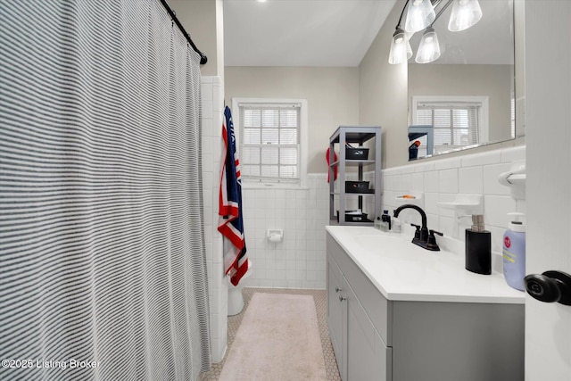 2100 Murray Ave, Louisville, KY 40205 - full bath with tile walls, vanity, a wainscoted wall, plenty of natural light, and tile patterned flooring