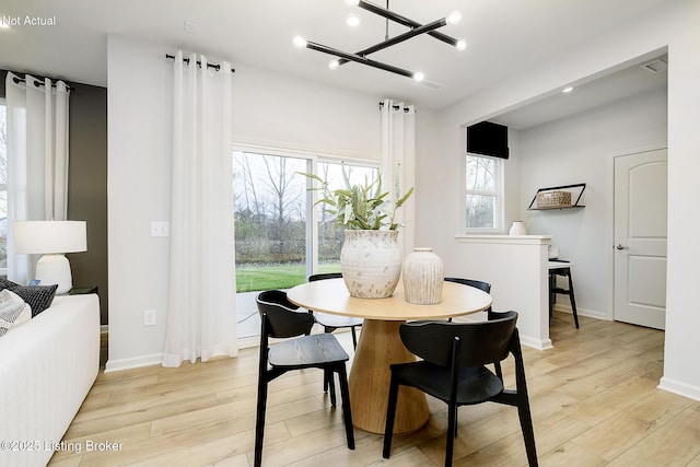 dining space with recessed lighting, baseboards, a chandelier, and light wood-type flooring