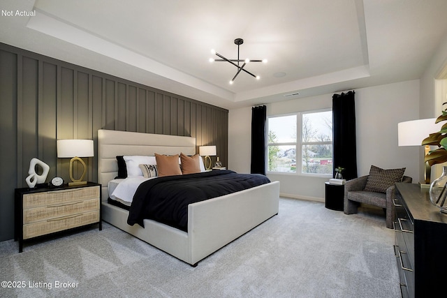 bedroom with an inviting chandelier, light carpet, and a tray ceiling