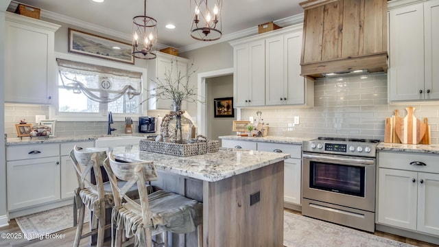 157 Tommy Ct, Shepherdsville, KY 40165 - kitchen with ornamental molding, a center island, white cabinets, stainless steel electric stove, and tasteful backsplash