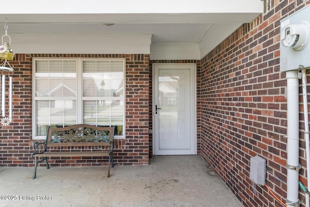 view of exterior entry with brick siding