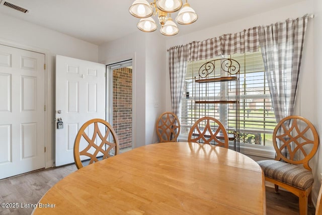dining area with a notable chandelier, wood finished floors, and visible vents