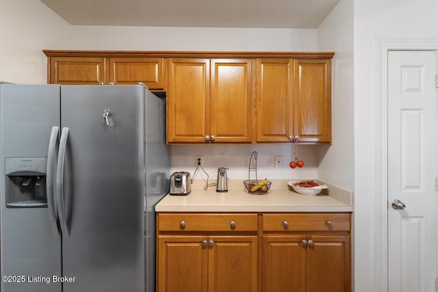 kitchen featuring brown cabinets and stainless steel fridge with ice dispenser
