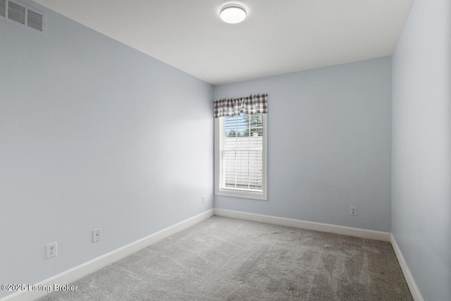 carpeted spare room with baseboards and visible vents