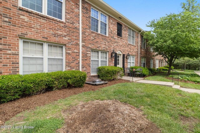 view of front of home with brick siding and a front lawn