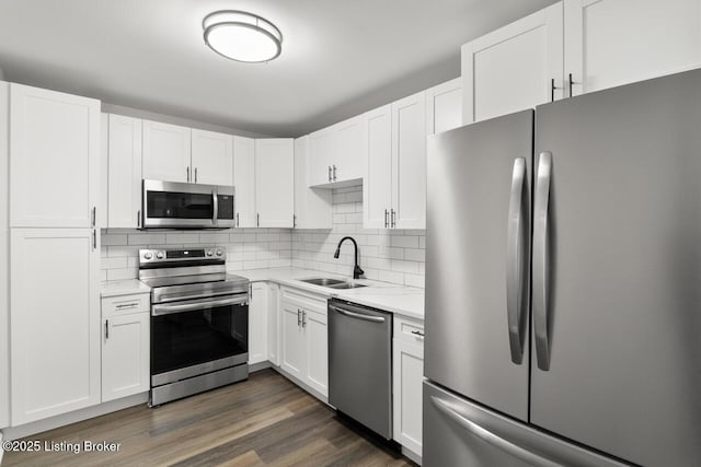 kitchen with a sink, stainless steel appliances, backsplash, and white cabinets