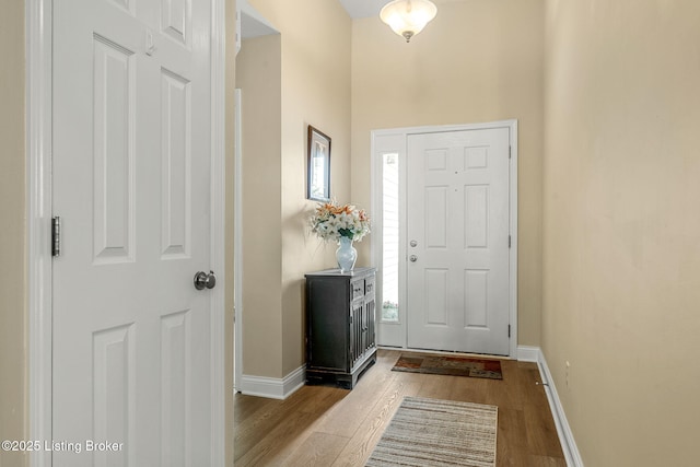 foyer with baseboards and wood finished floors