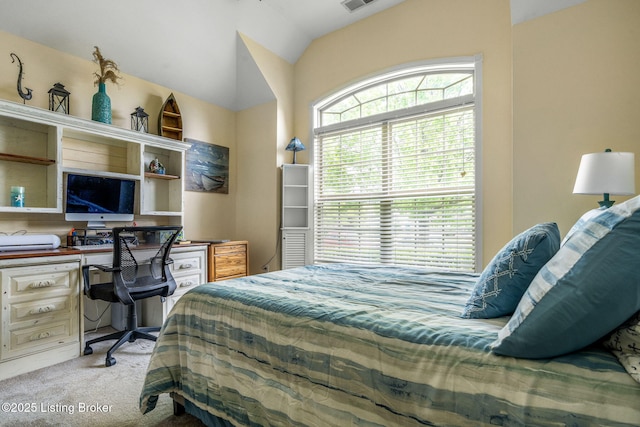 bedroom featuring built in study area, visible vents, light carpet, and lofted ceiling