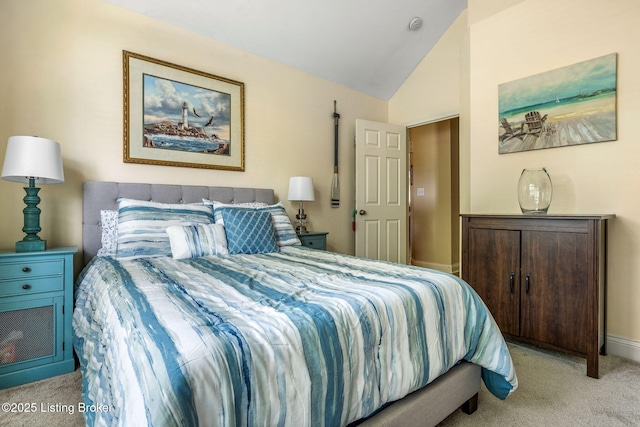 carpeted bedroom featuring baseboards and vaulted ceiling